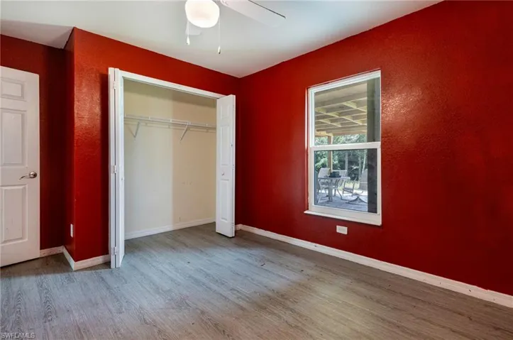 Unfurnished bedroom with ceiling fan, hardwood / wood-style floors, and a closet