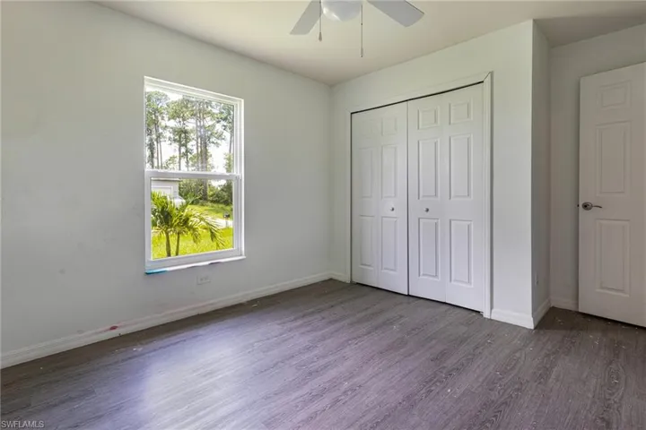 Unfurnished bedroom featuring ceiling fan, wood-type flooring, and a closet