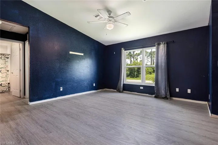 Unfurnished room with ceiling fan, wood-type flooring, and vaulted ceiling