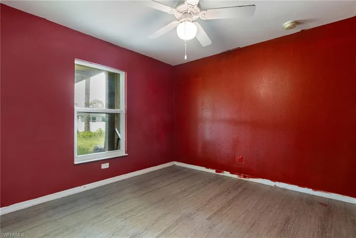 Empty room with ceiling fan and wood-type flooring