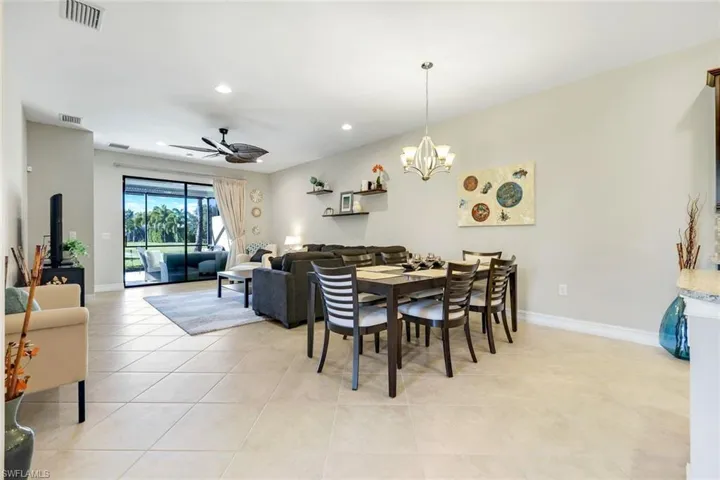 Dining area with ceiling fan, recessed lighting, light tile patterned floors, and a chandelier