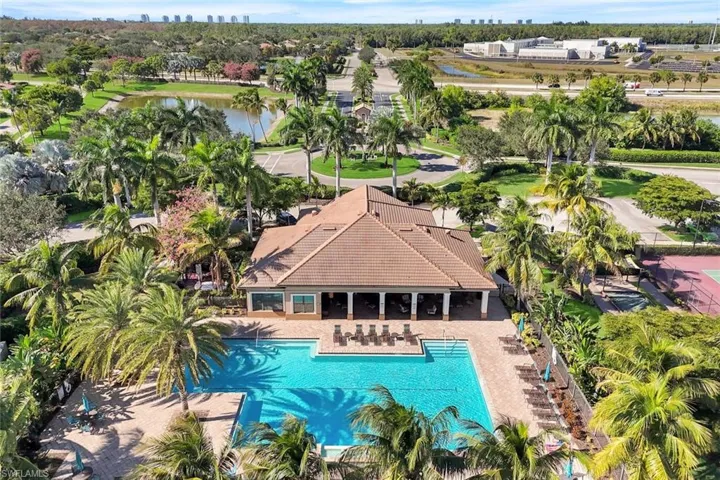 Community pool with a patio area, a view of skyline, a water view, and view of wooded area