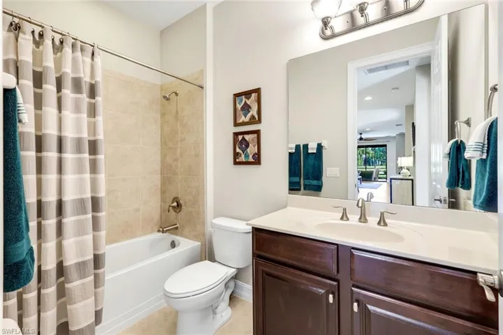 Full bathroom featuring shower / tub combo with curtain, vanity, and light tile patterned floors