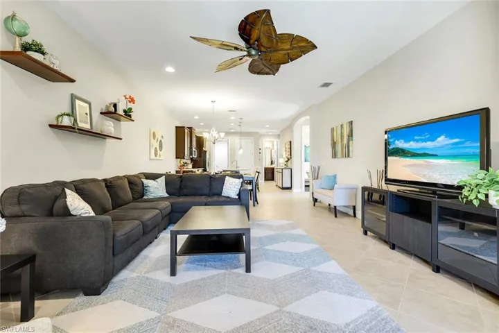 Living room with recessed lighting, ceiling fan, a chandelier, and light tile patterned floors