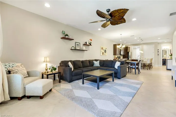 Living area featuring recessed lighting, a ceiling fan, light tile patterned floors, and a chandelier