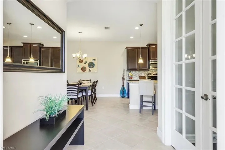 Kitchen featuring dark brown cabinetry, recessed lighting, decorative backsplash, a breakfast bar area, and hanging light fixtures