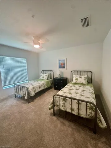 Bedroom with carpet floors, ceiling fan, and baseboards