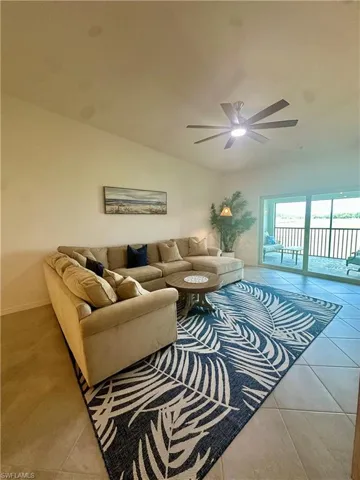 Living area featuring tile patterned floors, a ceiling fan, and baseboards