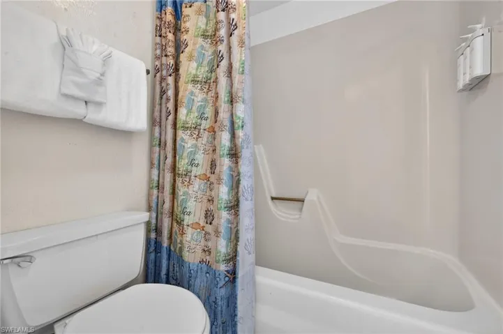 White fiberglass bathtub and shower surround with an integrated grab bar