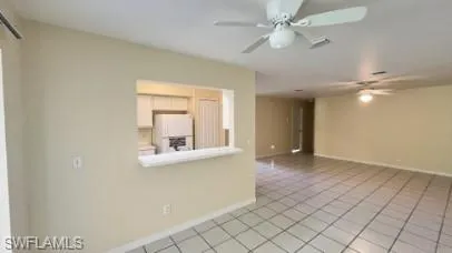 Unfurnished room with light tile patterned floors and ceiling fan