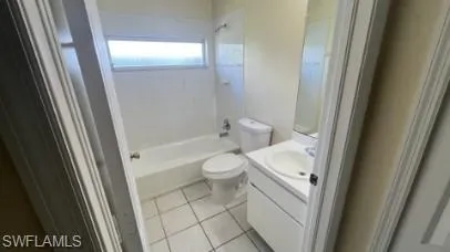 Bathroom with vanity, shower / bath combination, and light tile patterned flooring