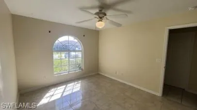 Empty room with ceiling fan and baseboards