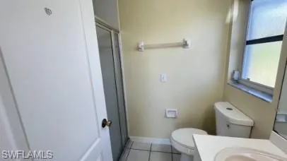 Bathroom with vanity, light tile patterned floors, and a shower stall