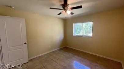 Spare room featuring a ceiling fan and light tile patterned flooring