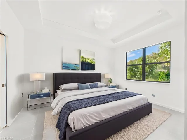 Bedroom with a tray ceiling and baseboards