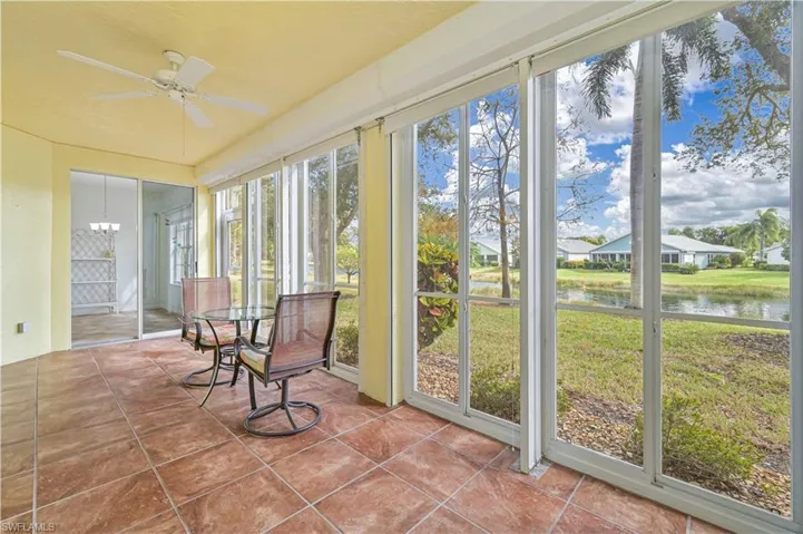 Sunroom / solarium with a water view and tile patterned flooring
