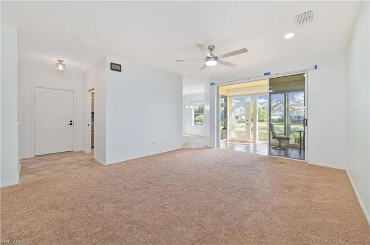 Unfurnished room featuring light carpet, ceiling fan, a chandelier, and recessed lighting