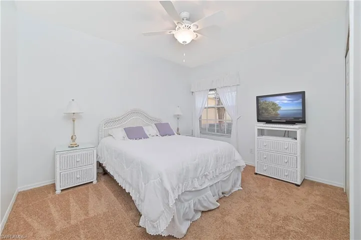 Bedroom with light colored carpet and ceiling fan