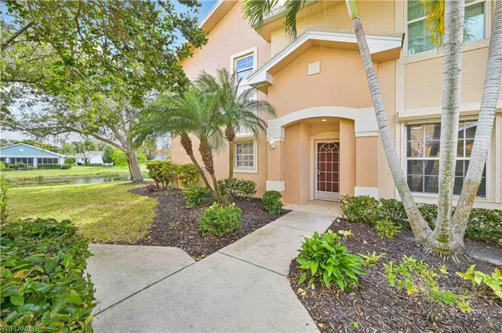 Entrance to property with stucco siding, a lawn, and a water view
