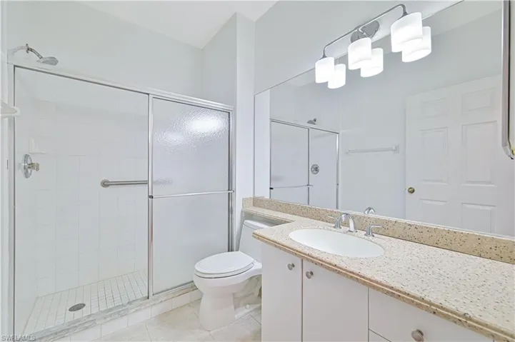 Full bath featuring vanity, a stall shower, and light tile patterned floors
