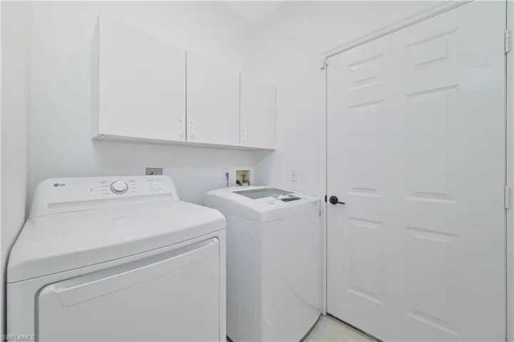 Laundry room with washing machine and clothes dryer and cabinet space