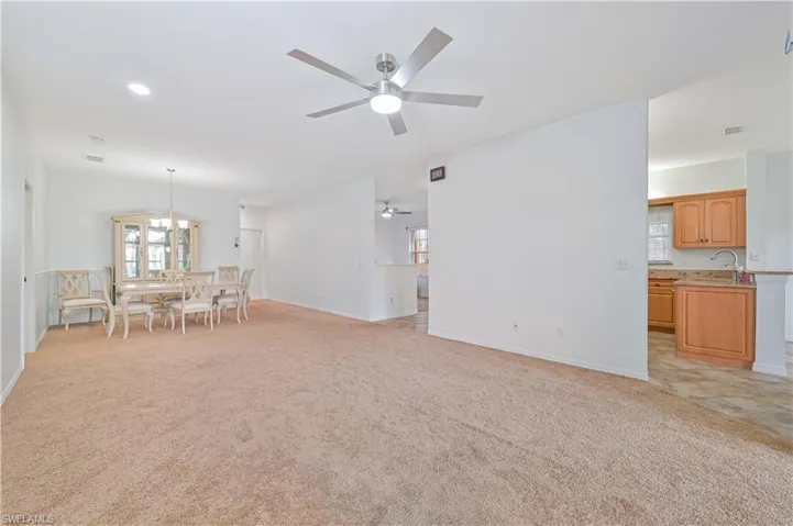 Living room featuring light colored carpet, a chandelier, a ceiling fan, and recessed lighting