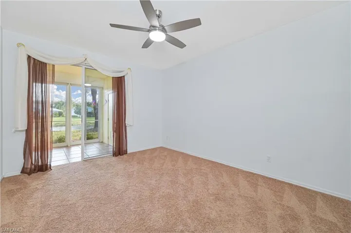 Empty room featuring carpet flooring and ceiling fan