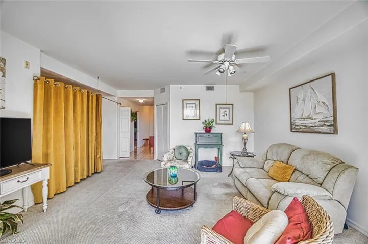 Carpeted living room with ceiling fan