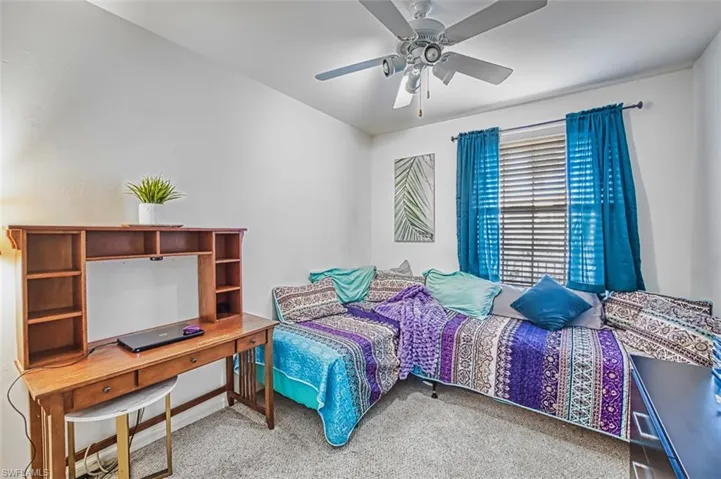 Bedroom with ceiling fan and light colored carpet