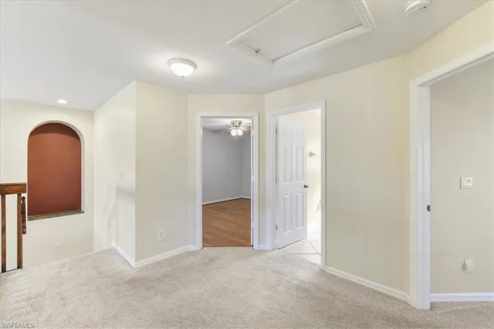 Empty room with light carpet and baseboards
