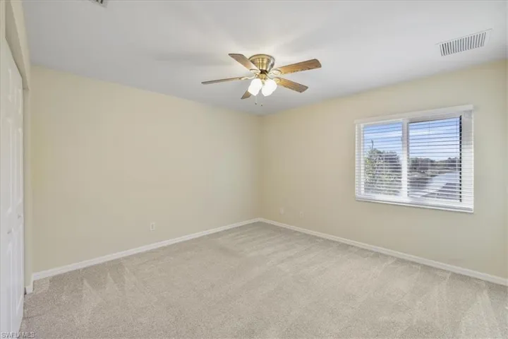 Empty room with light carpet and ceiling fan