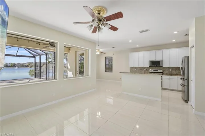 Kitchen featuring white cabinetry, a center island with sink, recessed lighting, tasteful backsplash, and stainless steel appliances