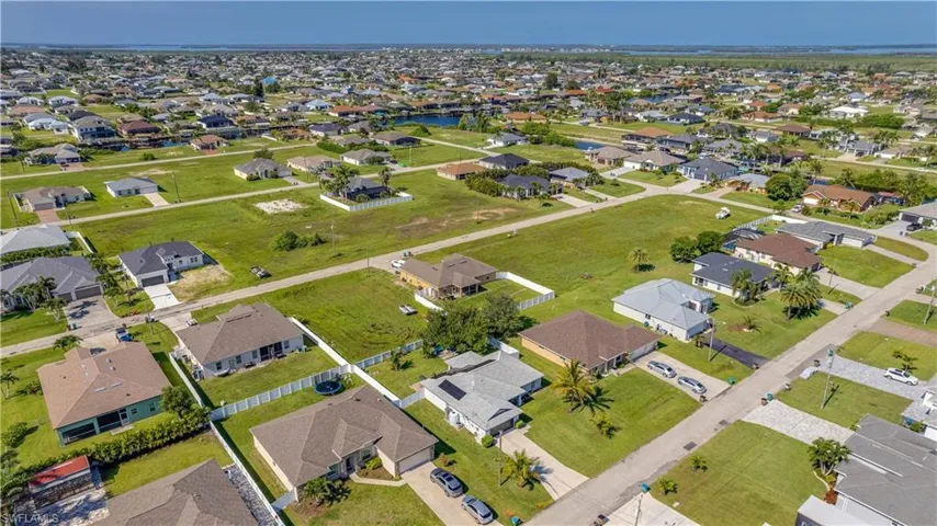 Aerial view of property's location featuring a nearby body of water and nearby suburban area