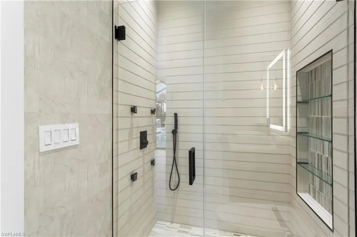 Luxurious second master bathroom offers a spa retreat with high-end finishes, rainfall shower, 4-jet and handheld showeheads.