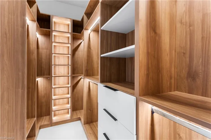 HIS-&-HER walk-in CLOSETS w/ custom WRAPAROUND LIGHTED CABINETRY