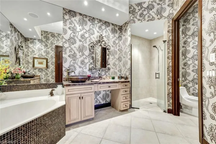 Bathroom with vanity, a shower stall, light tile patterned floors, a garden tub, and recessed lighting