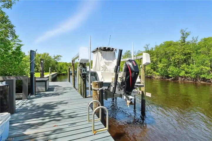 Dock area with boat lift and a water view facing South