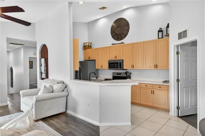 Kitchen featuring light wood-finish cabinetry, stainless steel appliances, and a white countertop