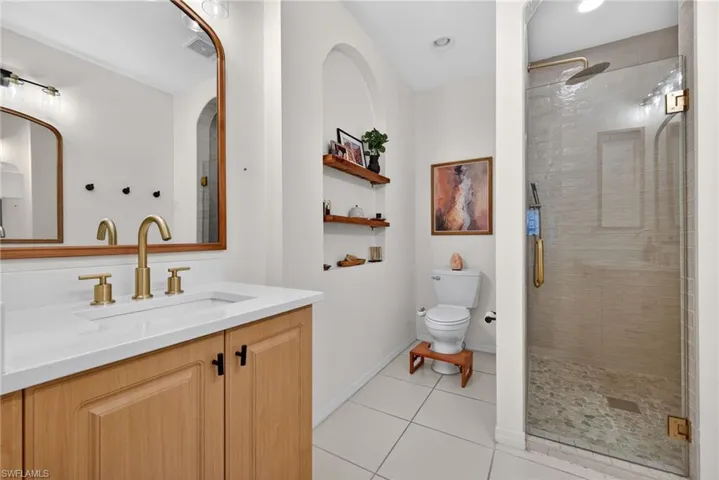 Primary Bathroom featuring a light wood-finish vanity with a white countertop and gold-finish faucet
