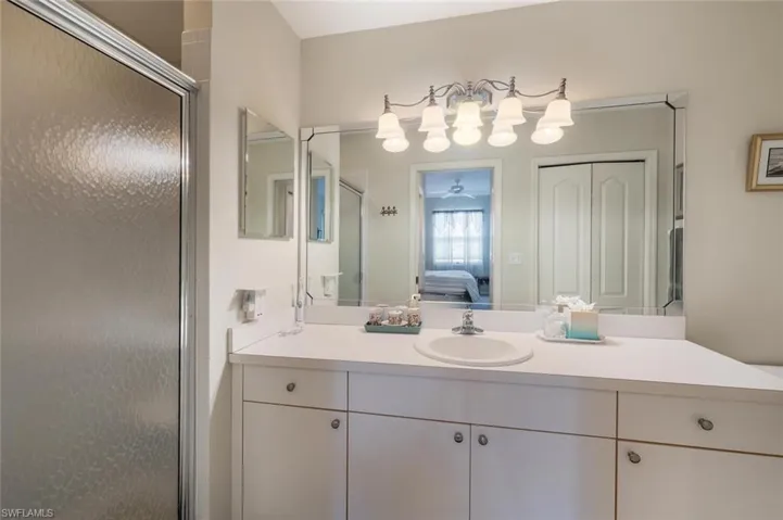 Ensuite bathroom with a shower stall, ensuite bath, vanity, and ceiling fan