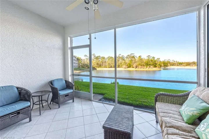 Sunroom featuring a ceiling fan and a water view
