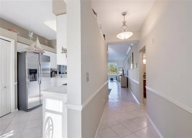 Hallway with light tile patterned floors and baseboards