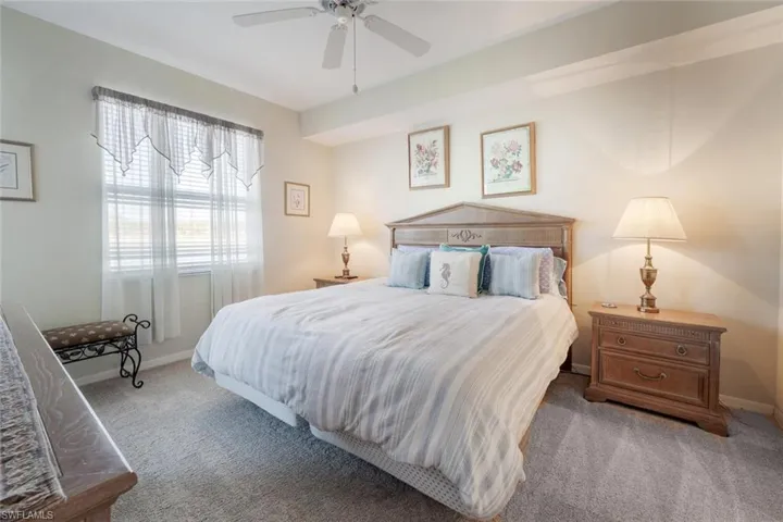 Carpeted bedroom featuring ceiling fan and baseboards