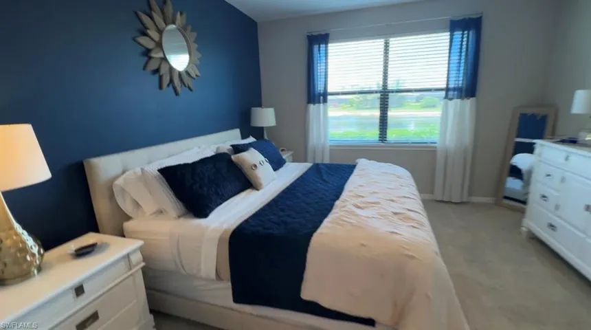 Bedroom featuring light carpet and baseboards