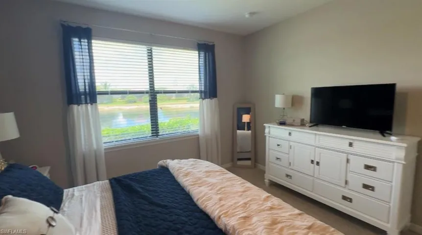 Bedroom with multiple windows and dark carpet