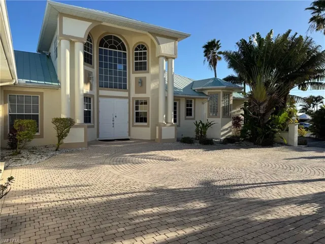 Property entrance with metal roof, a standing seam roof, and stucco siding