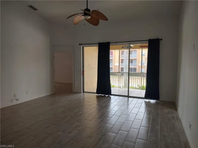 Unfurnished room with wood look ceramic tiles floors and a ceiling fan