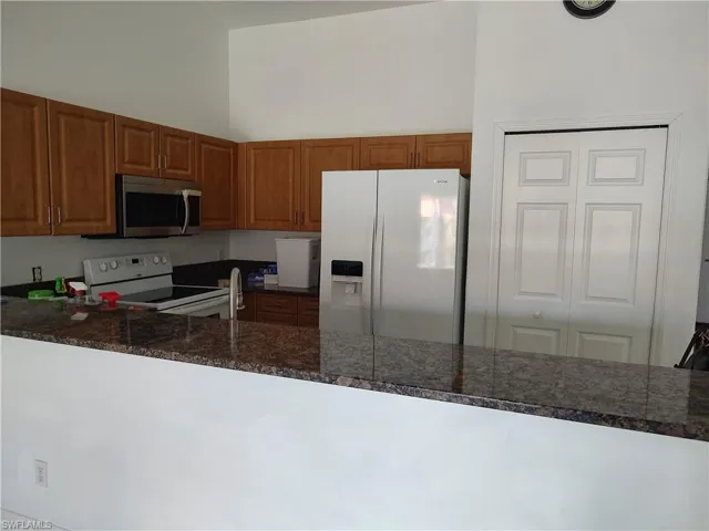 Kitchen featuring white appliances, wood finish cabinetry and a pantry
