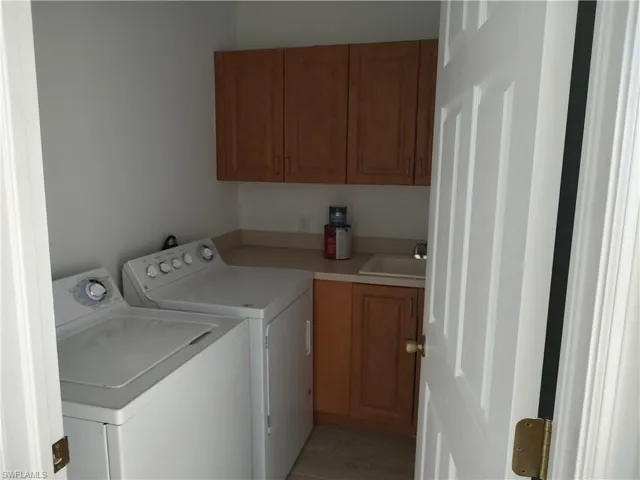 Laundry room featuring washer and clothes dryer, cabinet space,