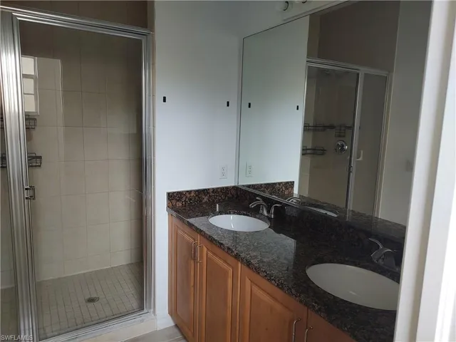 Full bathroom with double vanity and a stall shower